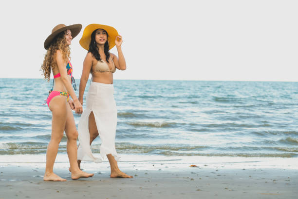 istock Happy women go sunbathing at sand beach in summer. 1019726948