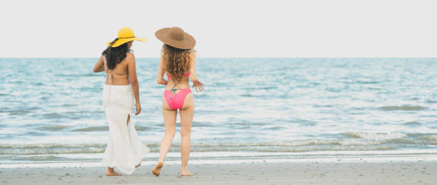 istock Happy women go sunbathing at sand beach in summer. 1019726982