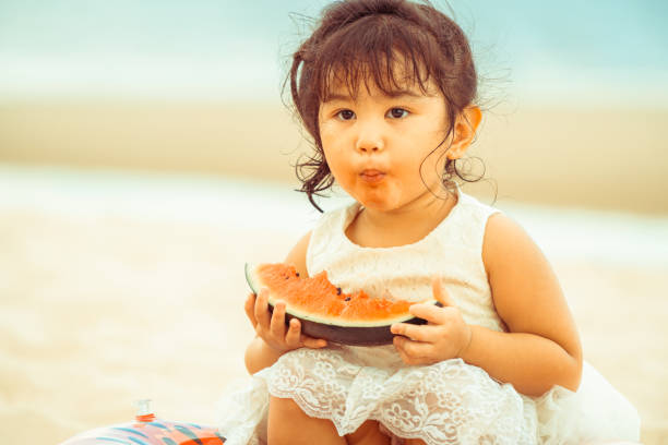 istock Adorable kid eating watermelon on the beach. 1019729058