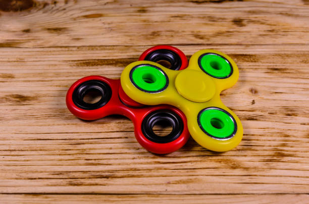 istock Two fidget spinners on wooden desk 1019762130