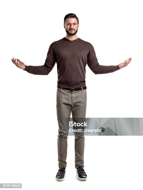 A Young Smart Looking Man Stands In Front View With Arms Widely Spread On The Sides Stock Photo - Download Image Now