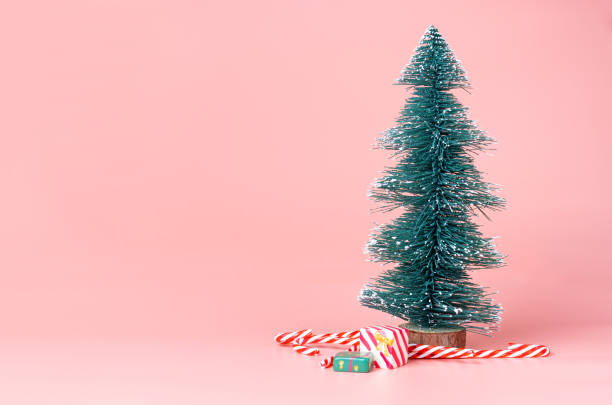istock Christmas tree with candy cane on pastel pink studio background.Holiday festive celebration greeting card with copy space to addng text. 1019794668