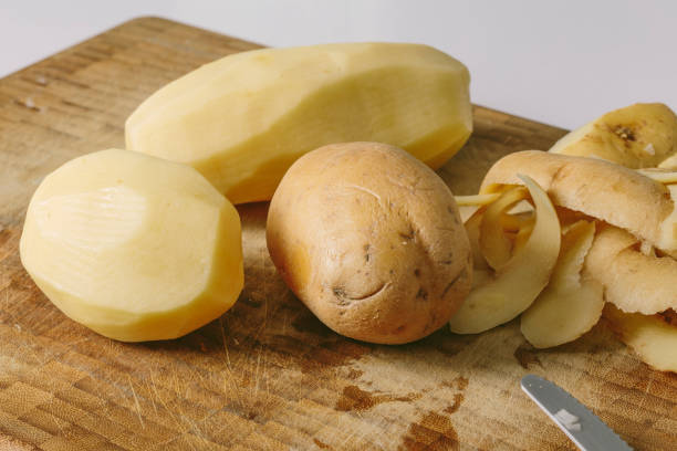 istock Peeling cooking potatoes on a wooden board 1019814202