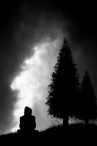 istock silhouette of someone sitting and watching the approaching storm 1019816914