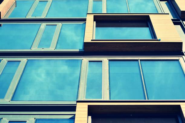 istock Modern office building facade abstract fragment, shiny windows in steel structure, retro stylized colorful tonal filter effect 1019822474