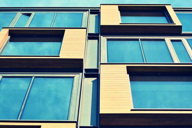istock Modern office building facade abstract fragment, shiny windows in steel structure, retro stylized colorful tonal filter effect 1019822556