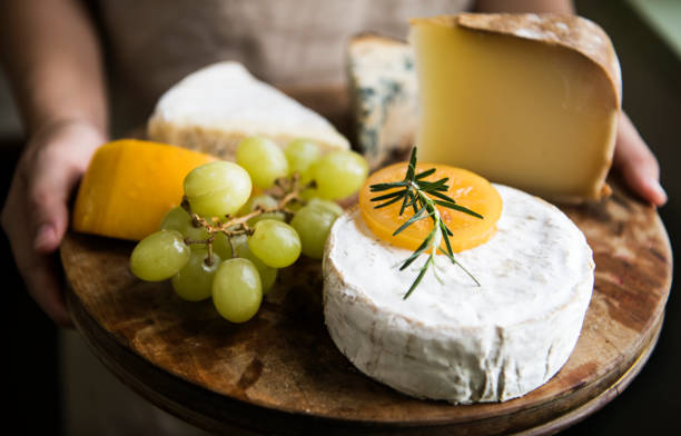 variazione di formaggio e uva verde su un piatto di legno fotografia di cibo idea ricetta - cheese platter foto e immagini stock