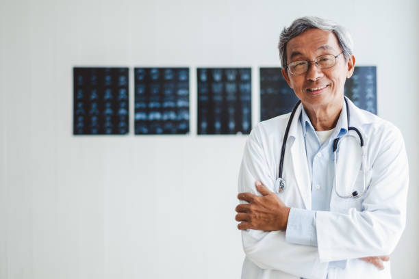 ancien médecin asiatique de portrait sur fond de radiographie, concept médical asiatique - male doctor photos et images de collection