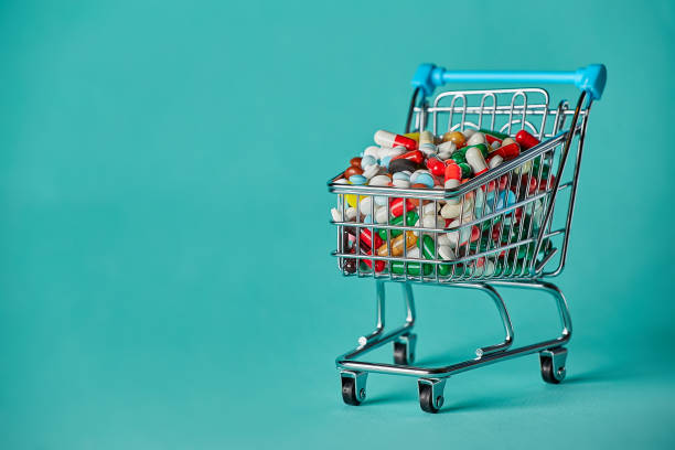 Trolley with pills on a blue background. Concept: cost of medicines. stock photo