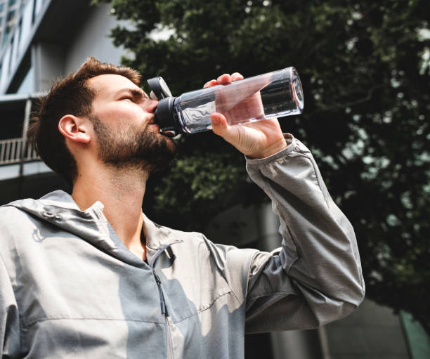 istock Man drinking out of a water bottle 1019863190