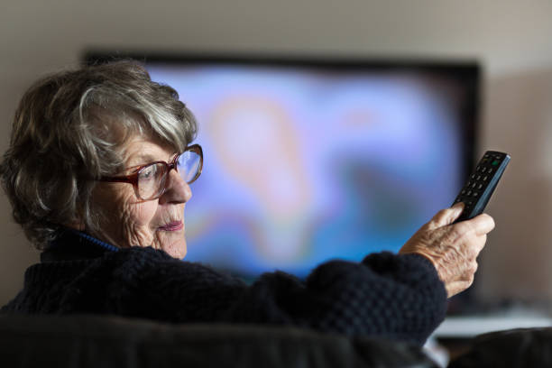 istock Senior woman holding TV remote control 1019870976