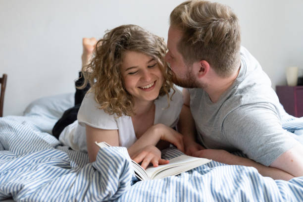 istock Young couple reading book in bed 1019877230