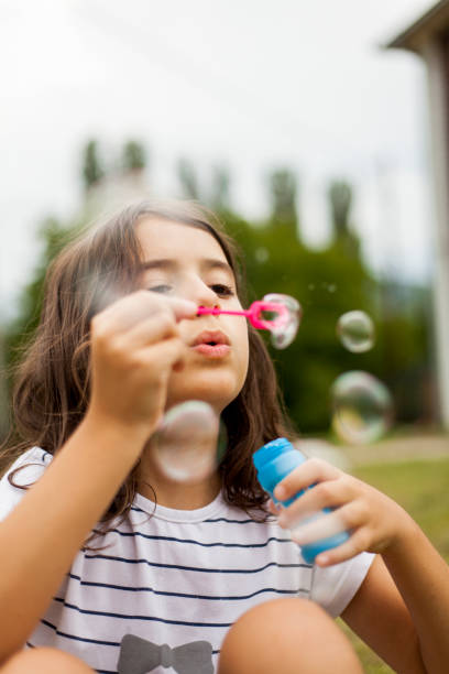 istock girl blowing soap bubbles 1019881582