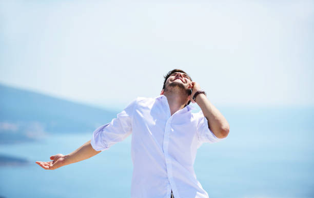 istock Handsome business man standing on a seaside and looking into the distance. 1019886162