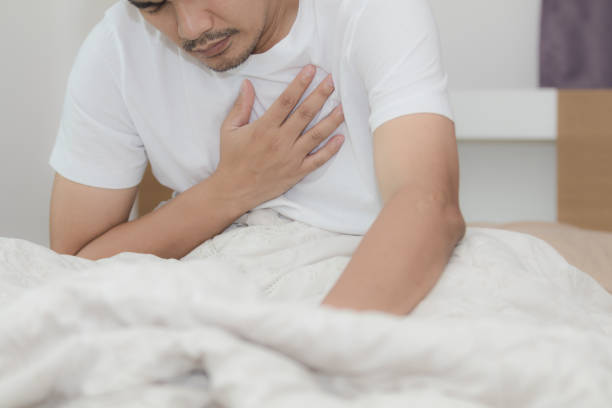 istock Asian man has chest pain while lying on the bed in bedroom 1019886340