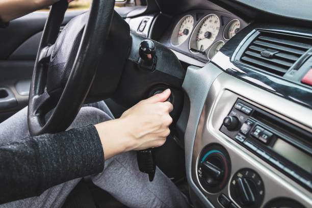 la ragazza avvia l'auto inserendo la chiave di accensione nella serratura. - accensione foto e immagini stock