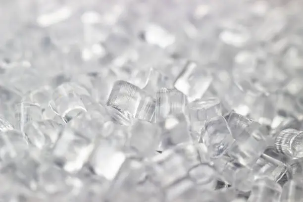 Photo of Transparent Plastic granules. Polymer pellets. Isolated on a black background.