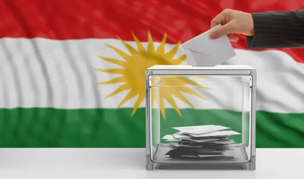 Elections in Kurdistan. Man's hand puts an envelope in a glass election ballot box on a waving Kurdistan flag background. 3d illustration
