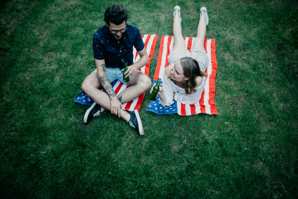 istock Young couple having beer in a park 1019892446