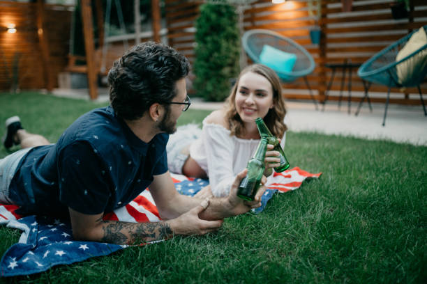 istock Young couple having beer in a park 1019894806