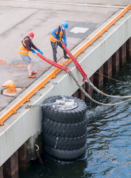 trabalhador portuário ou trabalhador do porto com corda protegendo um navio de encaixe - industrial ship dock worker engineer harbor - fotografias e filmes do acervo