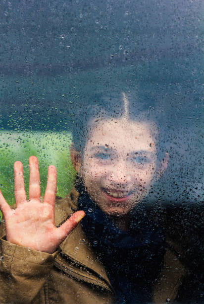 little girl in train waving from the window