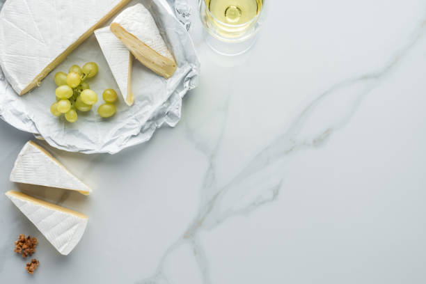 istock flat lay with glass of wine, camembert cheese and grape on white marble surface 1019913080