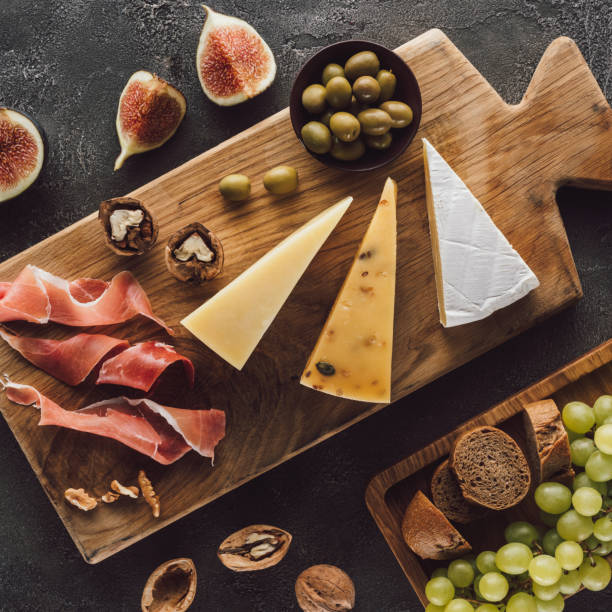 istock flat lay with assorted cheese, jamon and fruits on dark surface 1019913214