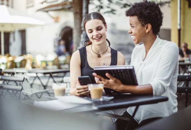 istock Two Young Businesswomen at a Sidewalk Cafe 1019913434