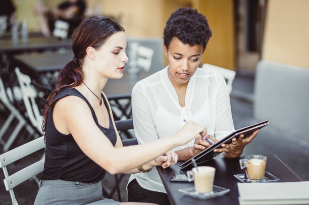 istock Two Young Businesswomen at a Sidewalk Cafe 1019913782