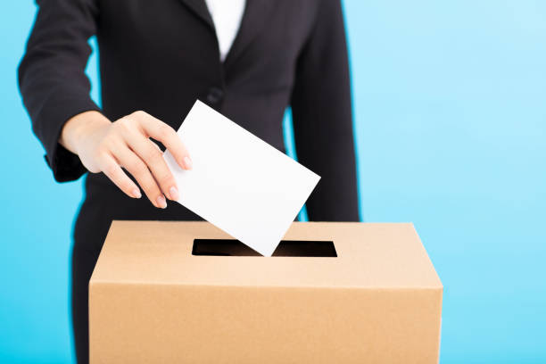 istock Ballot box with person casting vote on blank voting slip 1019914662