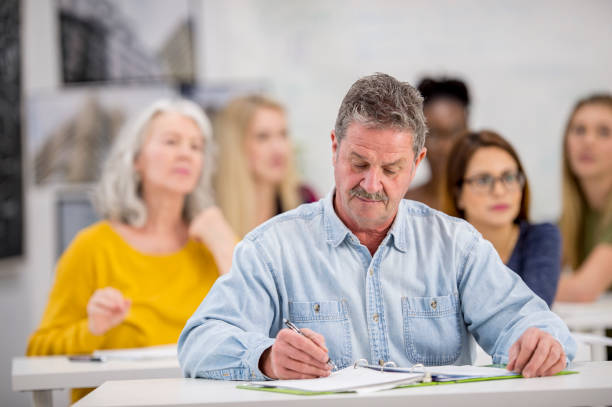 man taking notes - night school imagens e fotografias de stock