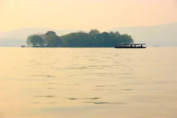 Ink Painting like view in West Lake, Hangzhou, China. Like Poetry as well. Little ship, little isle. Signature view of Hangzhou for tourist. Morning time.