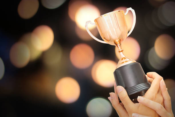 istock Winner hold trophy with abstract bokeh light background 1019921448