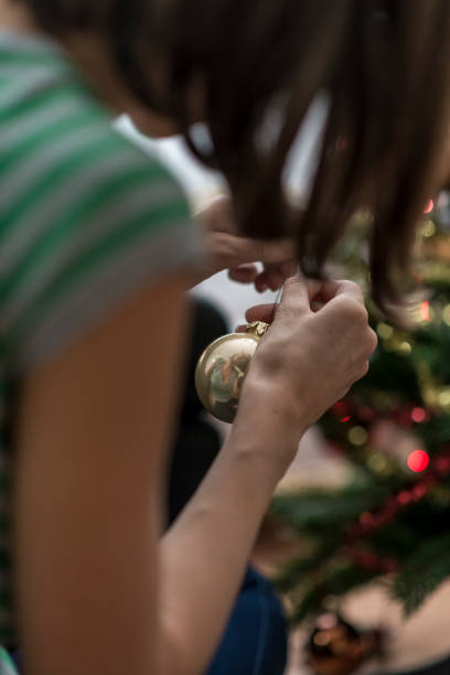 istock Woman decorating Christmas tree with golden bauble 1019921590