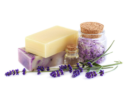 Lavender Spa products and lavender flowers on a white background. Handmade soap, essential oil and sea salt in glass bottles. Natural spa treatment