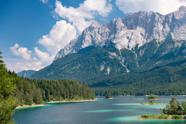 The beautiful Lake Eibsee at the foot of the famous and highest Mountain Zugspitze in Bavaria, Southern Germany. Lots of tourists enjoying this perfect summer day on the lake. Converted from RAW.