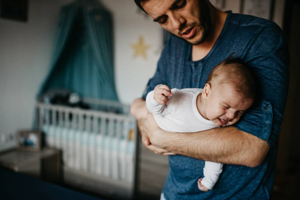 istock Dad Holding crying baby in the colic carry 1019928764
