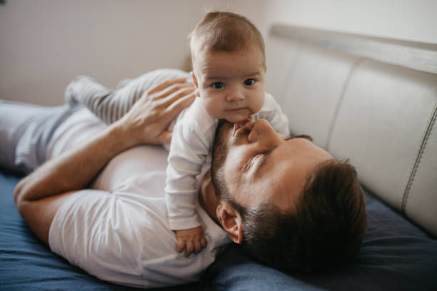 istock Father playing in bed with his little baby boy 1019932494