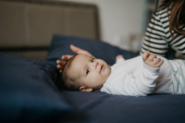 istock Mother playing with her newborn son in bed 1019932762