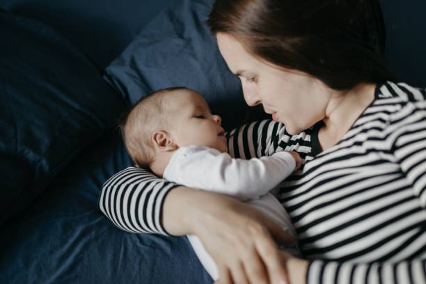 istock Mother playing with her newborn son in bed 1019932942