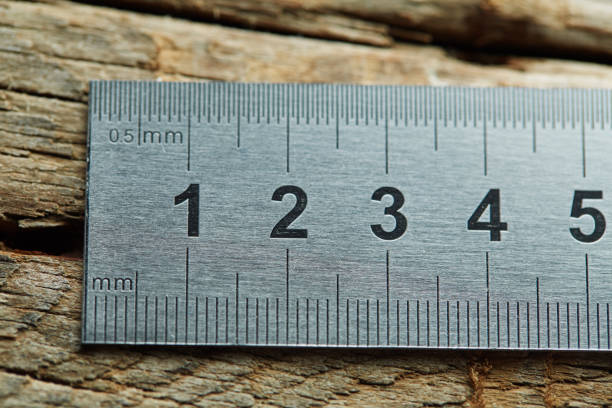Yellow old wooden folding ruler, meter, isolated on white background with reflections.