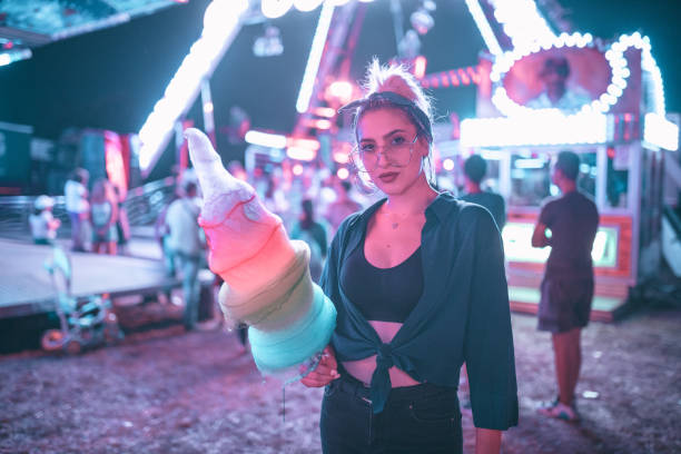 istock Young woman eating cotton candy during a carnival 1019945090