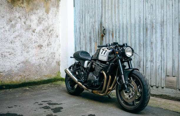 Customized motorcycle in front of garage door Shiny customized motorcycle parked in front of garage door used motorcycle parts stock pictures, royalty-free photos & images