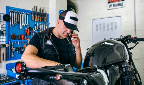 istock Mechanic talking phone while fixing motorbike 1019946672