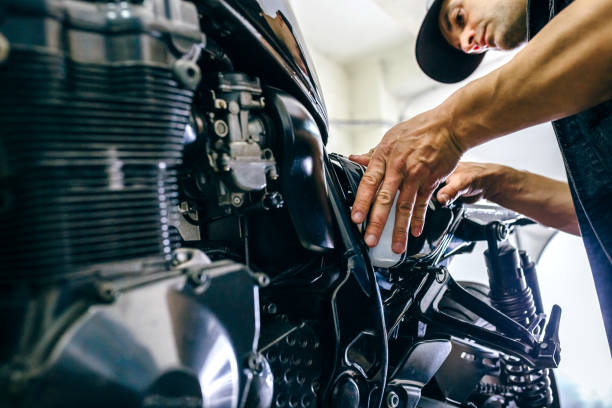 Mechanic repairing customized motorcycle Mechanic repairing customized motorcycle in the workshop dismantling photos stock pictures, royalty-free photos & images