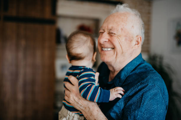 urgroßvater voller freude umarmt sein urenkel - grandson stock-fotos und bilder