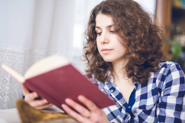 istock Woman relaxing indoor and reading favorite book. 1019963882