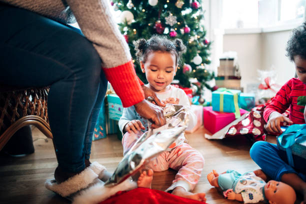 istock Helping her Daughter Open Presents on Christmas Morning 1019965980