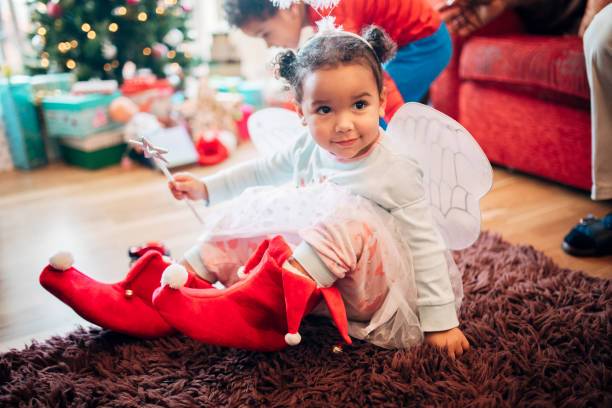 bambina che prova le pantofole di natale - humor inspiration angel child foto e immagini stock